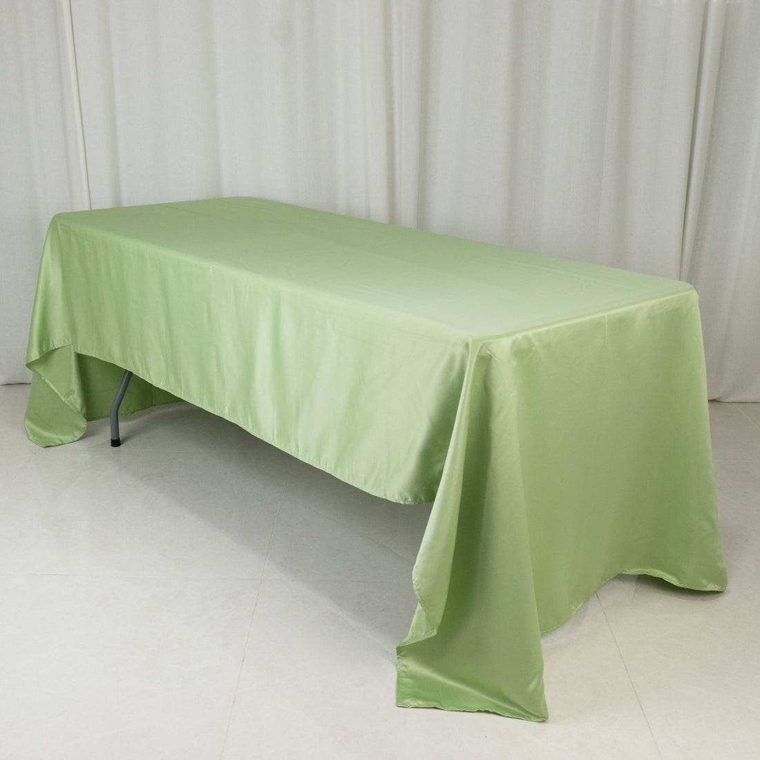 Green tablecloth draped over a table in a studio setting.