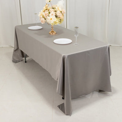 Gray tablecloth draped elegantly over a banquet table set with plates and glasses.