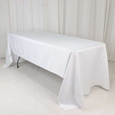 White tablecloth draped over a folding table in a studio setting