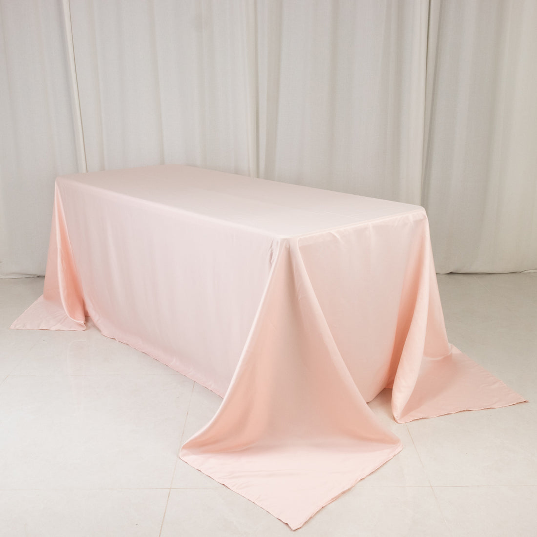 Pink tablecloth draped elegantly over a table in a studio setting.