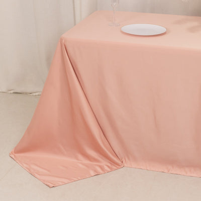 Peach tablecloth draped elegantly over a table with a plate on top.