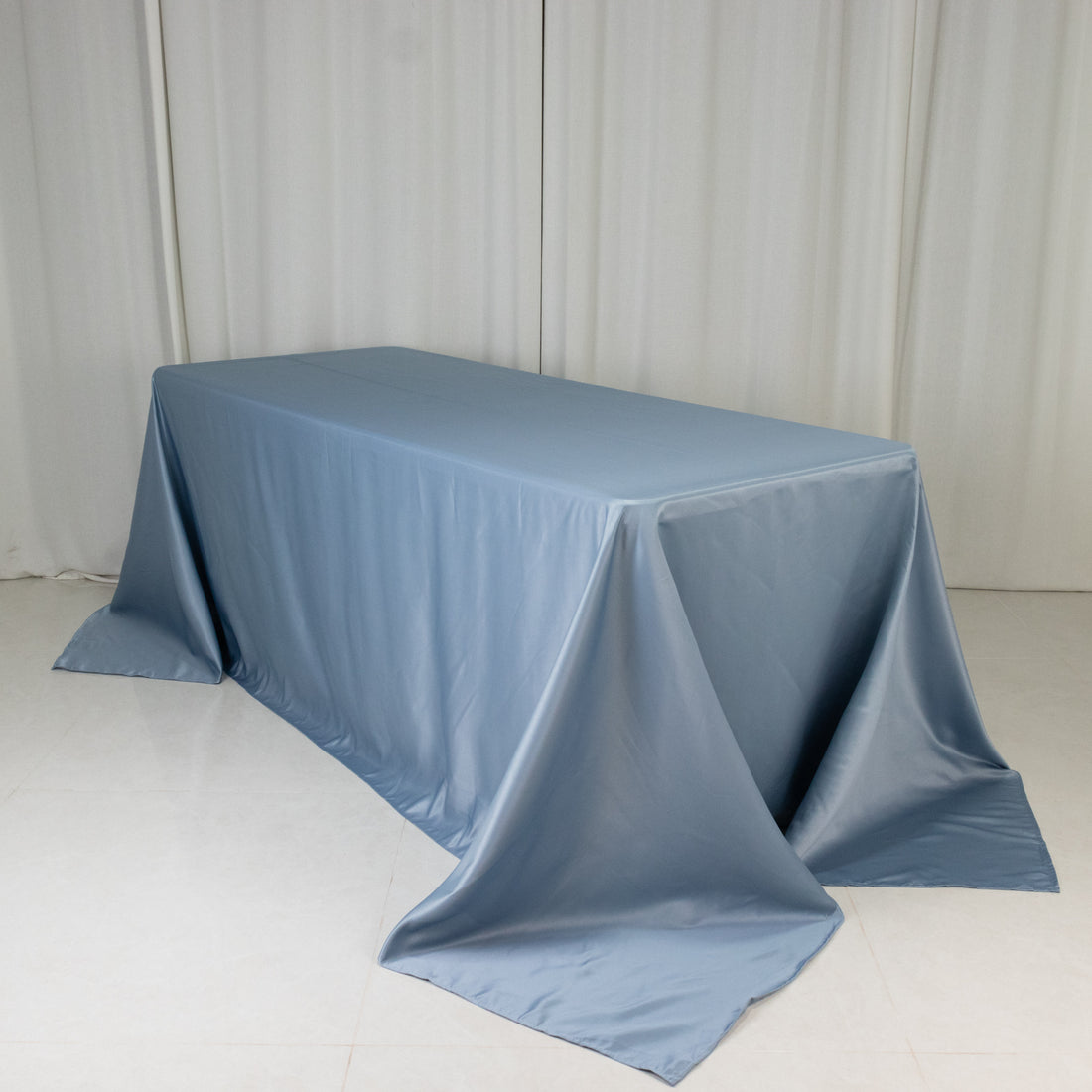 Blue tablecloth draped elegantly over a table against a plain backdrop.