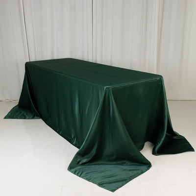 Green satin tablecloth draped over a rectangular table