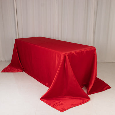 Red satin tablecloth draped elegantly over a rectangular table.