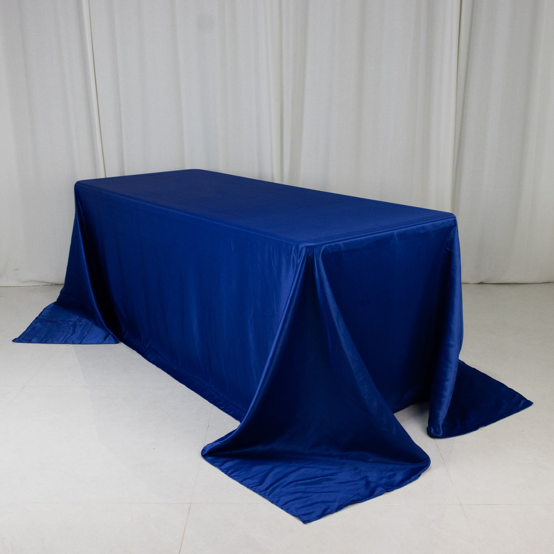 Blue tablecloth draped over a rectangular table in a studio setting.