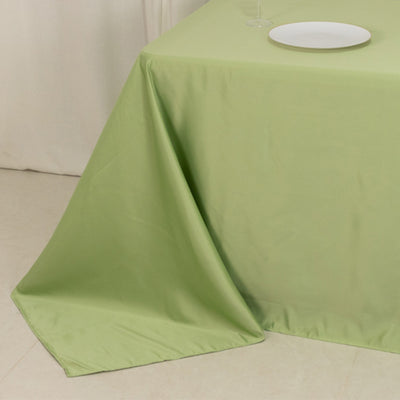 Green tablecloth draped elegantly over a table with a plate on top.