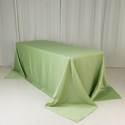 Green satin tablecloth draped over a rectangular table.