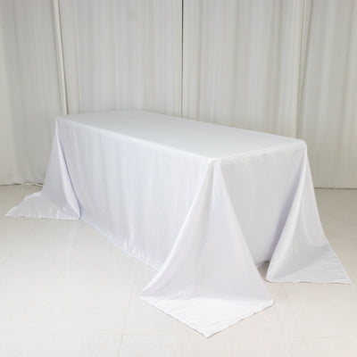 White table covered with a smooth tablecloth in a studio setting.