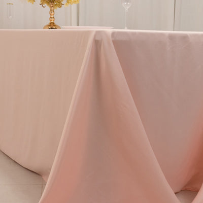 Elegant pink tablecloth draped over a table with floral centerpiece.