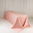 Pink tablecloth draped over a long table in a studio setting.