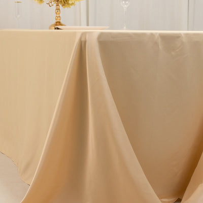 Beige tablecloth draped elegantly over a table with floral centerpiece.