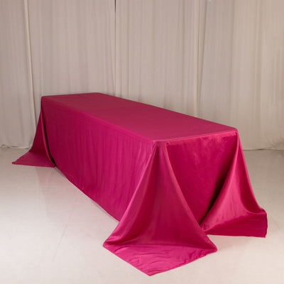 Pink tablecloth draped over a long table in a studio setting.