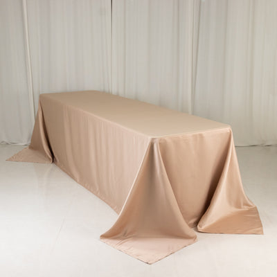 Rectangular beige tablecloth draped over a long table in a studio setting.