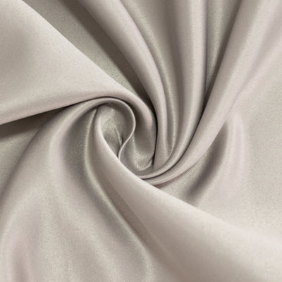 Silky beige fabric with a smooth texture, elegantly twisted in a spiral.