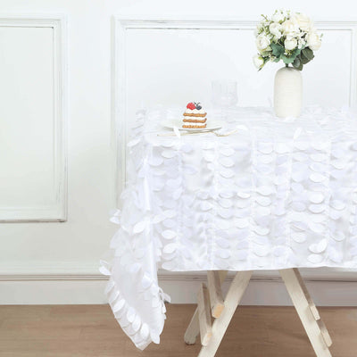White tablecloth with textured leaf design styled with vase and dessert.