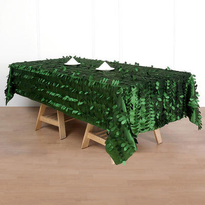 Green leaf tablecloth draped over a wooden table, perfect for outdoor events.
