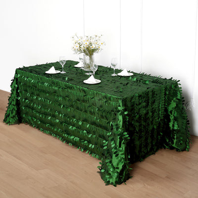 Green leaf-patterned tablecloth on a dining table set for a meal.