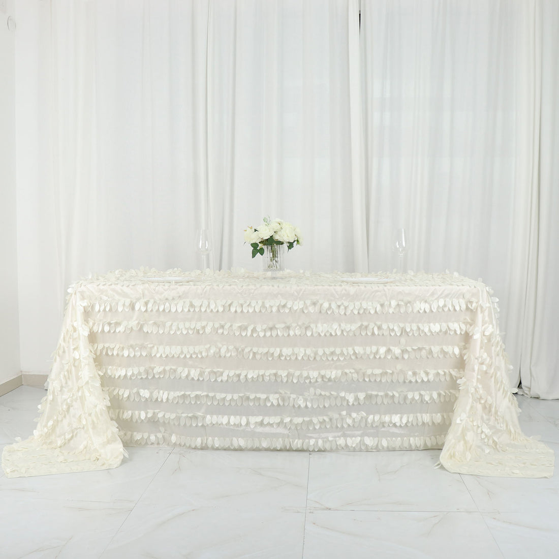 White textured tablecloth draped on a table with floral centerpiece.