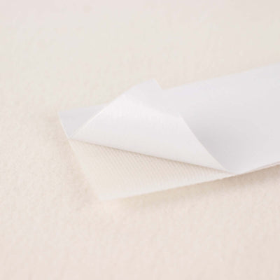 White adhesive paper roll with a textured underside for crafts and labeling.