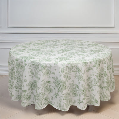Round floral tablecloth on a wooden table in a bright room.