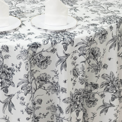 Floral tablecloth with black and white design on a dining table.