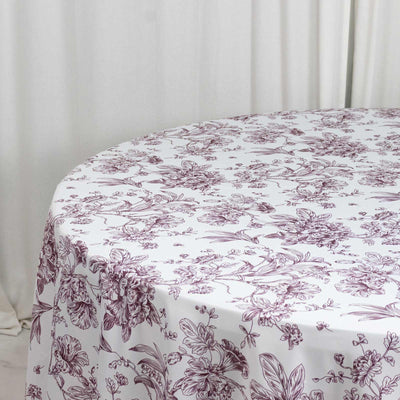 White floral tablecloth with purple botanical print on a round table