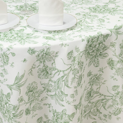 Green floral patterned tablecloth on a white table setting.