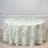 Round floral tablecloth in soft green and white design on a light wood floor.