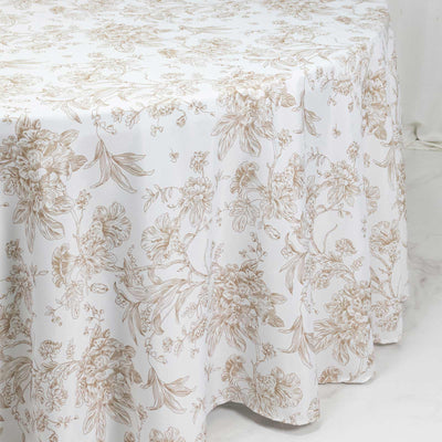 White floral tablecloth with gold botanical print, draped over a table