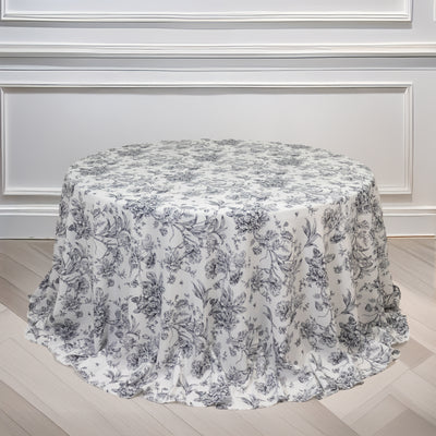 Floral print round tablecloth on a wooden floor.