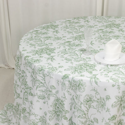 White tablecloth with green floral pattern on a round table.
