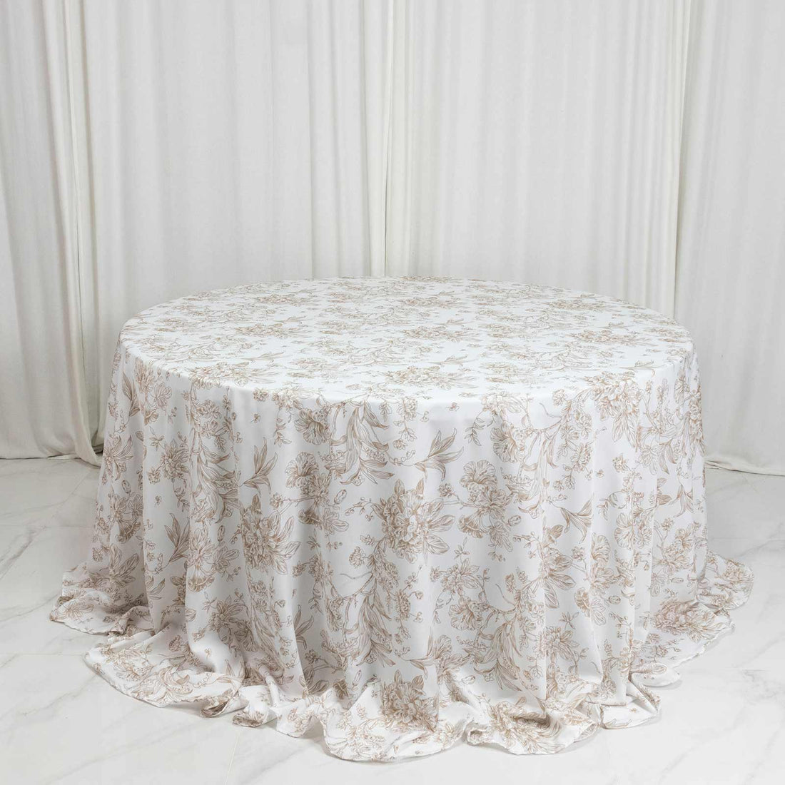 Round floral tablecloth in beige and white with elegant draped fabric
