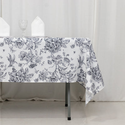 Floral print tablecloth on a dining table with napkins and glassware.