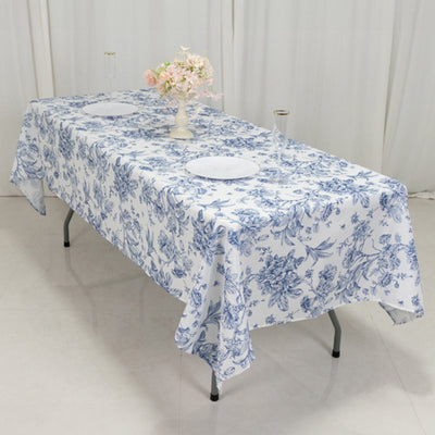 Floral pattern tablecloth on a dining table with plates and glasses.