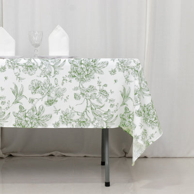 Floral patterned tablecloth draped over a table with glassware and napkins.