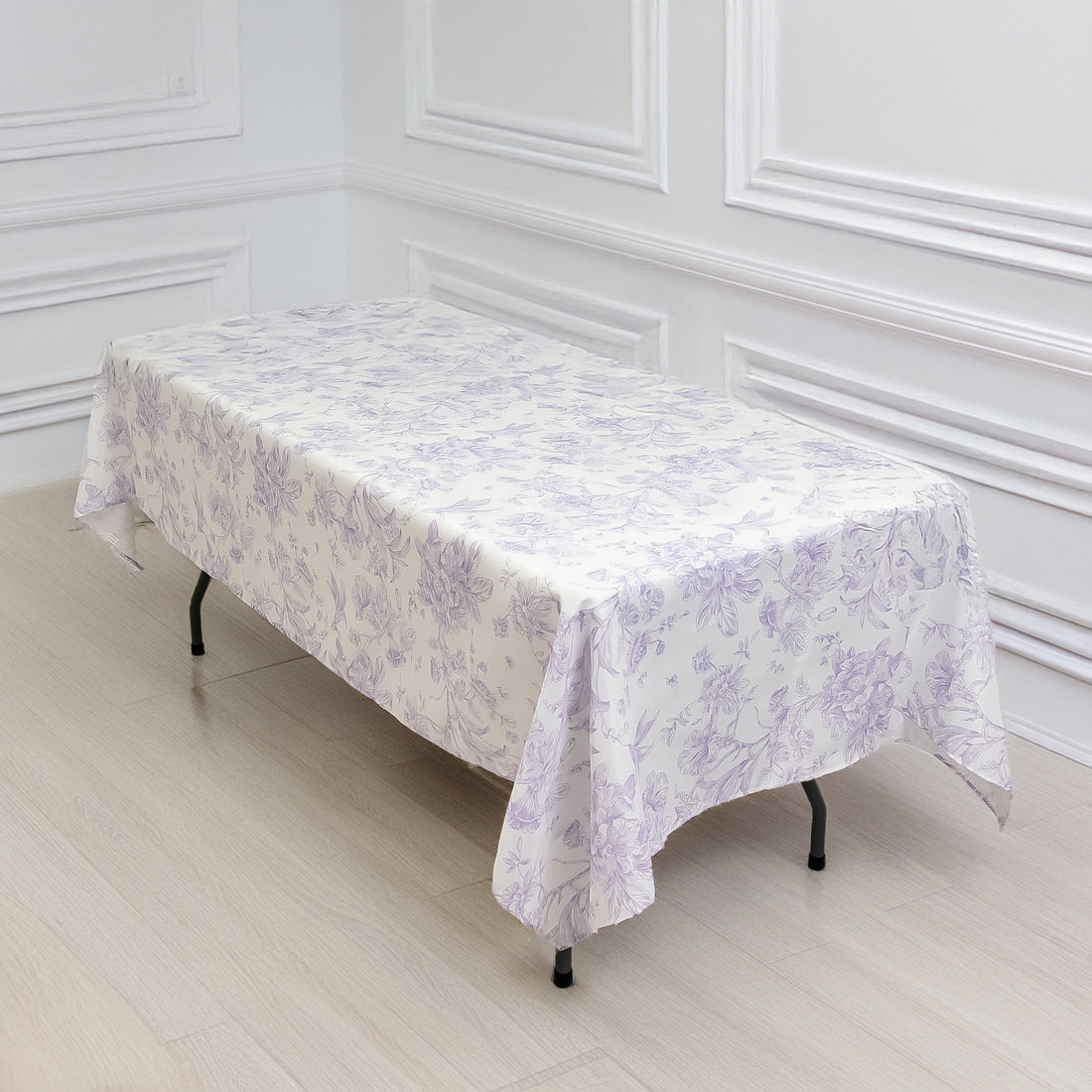 Purple floral tablecloth draped over a table in a bright, minimalistic setting.