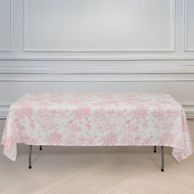 Pink floral tablecloth draped over a folding table in a bright room.