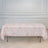 Pink floral tablecloth draped over a folding table in a bright room.