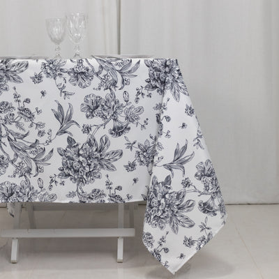 Floral black and white tablecloth draped on a table with glasses