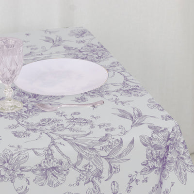 Floral patterned tablecloth with a plate and glass on a dining table.