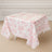 Floral patterned tablecloth draped over a table in a light interior setting.