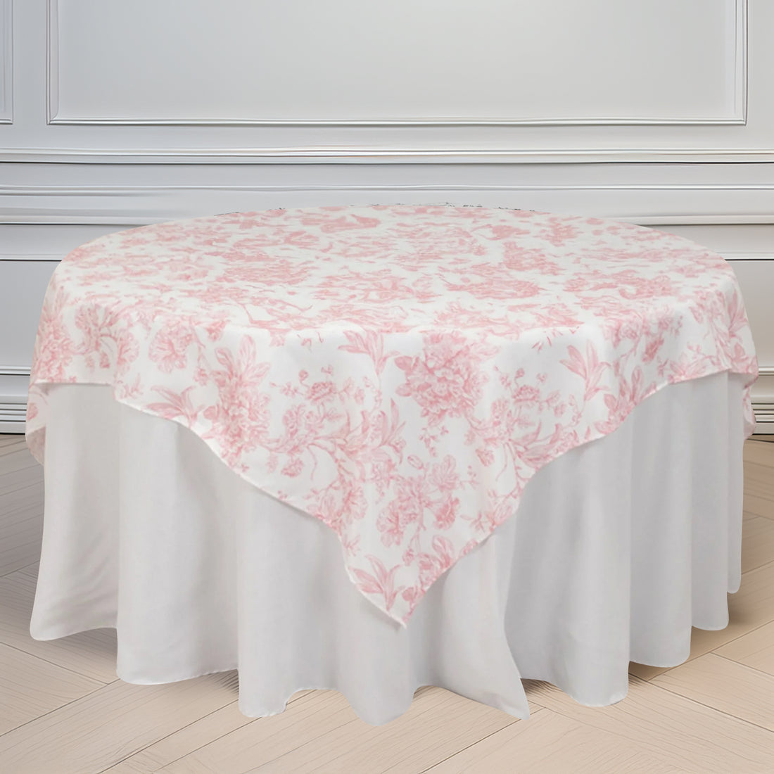Floral pink and white tablecloth draped over a round table