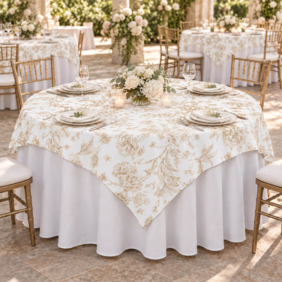 Elegant wedding table with floral centerpiece, gold chairs, and white linens