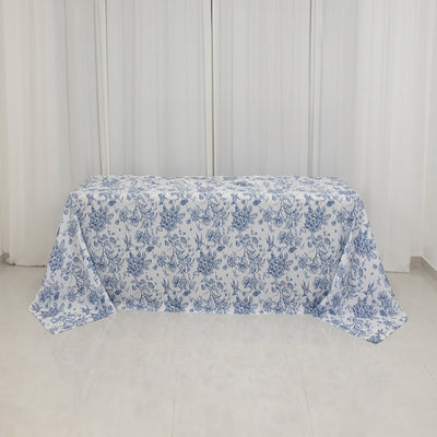 Blue floral tablecloth draped over a table in a bright room.