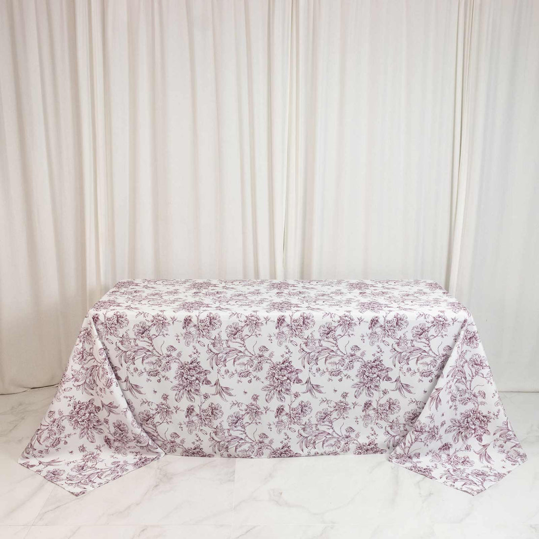 Floral pink tablecloth on rectangular table with cream curtains background
