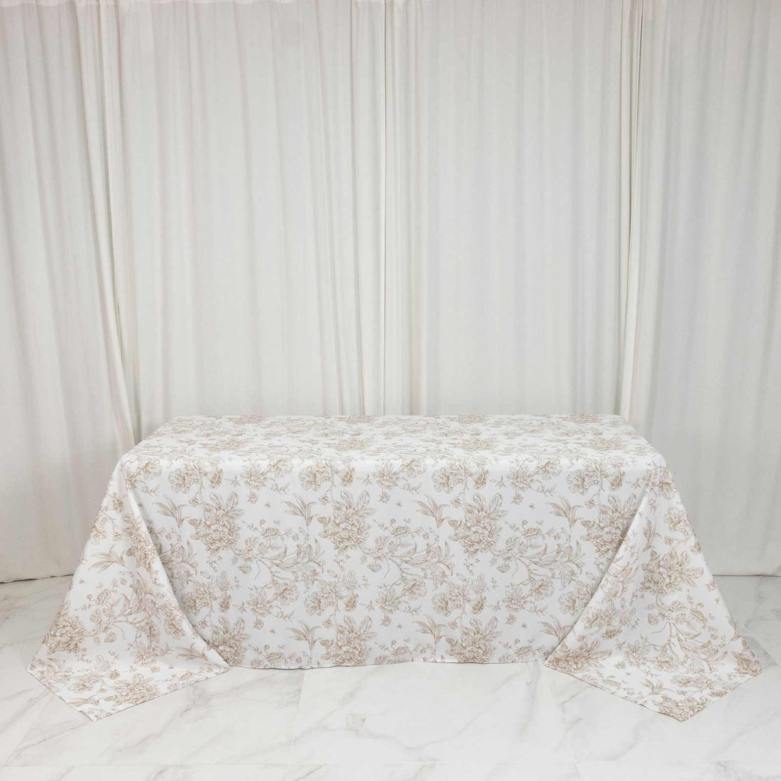 Floral tablecloth on table against white curtain backdrop