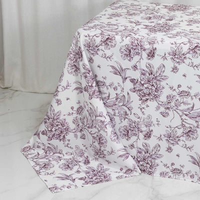 Floral printed tablecloth draped over table on white marble surface