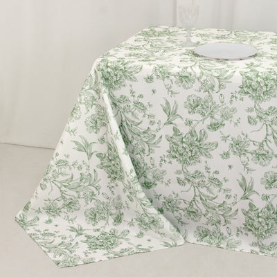 Floral patterned tablecloth with green and white design on a table.