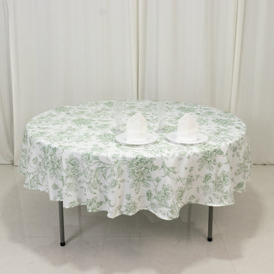 Round table with floral tablecloth and plates set for dining.
