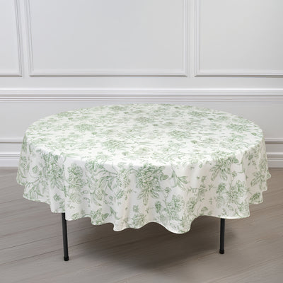 Round floral tablecloth in green and white on a table.